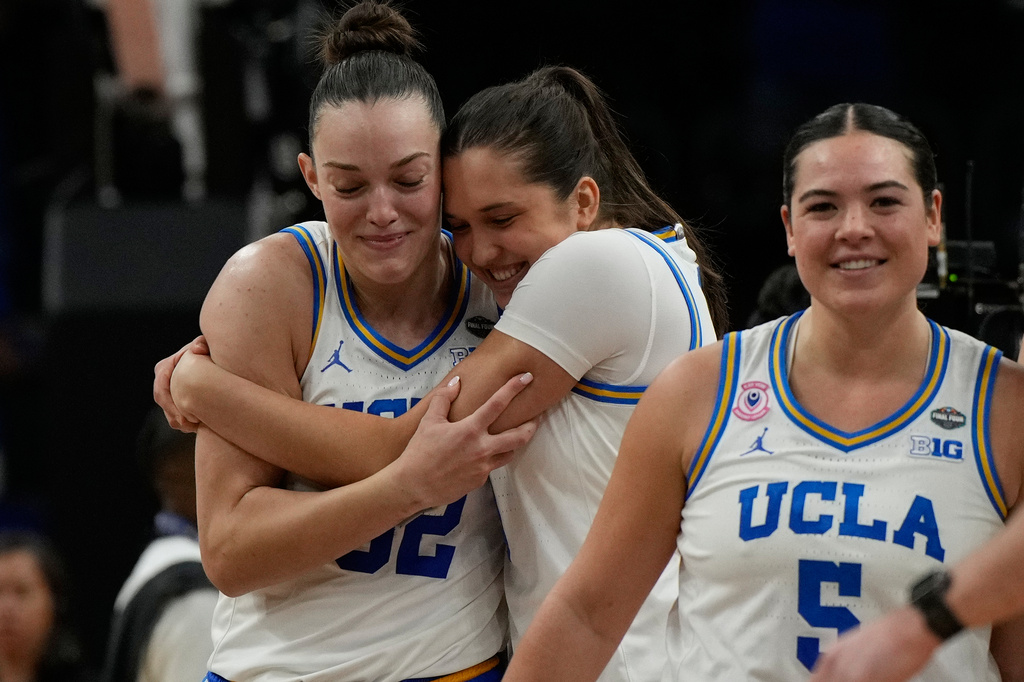 UCLA forward Angela Dugalic, left, and UCLA guard Charlisse Leger-Walker (5) embrace after defeating Texas in a women's NCAA college basketball tournament semifinal game at the Final Four, Friday, April 3, 2026, in Phoenix. (AP Photo/Ross D. Franklin)