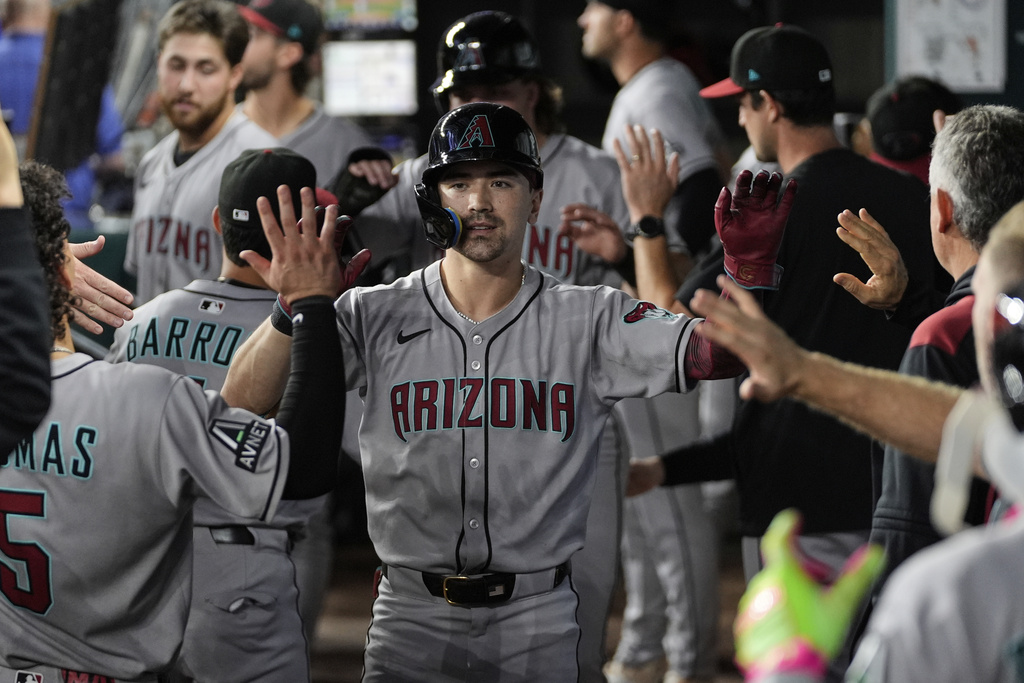 Arizona Diamondbacks' Corbin Carroll celebrates his two-run home run with the team in the third inning of a baseball game against the Texas Rangers Monday, Aug. 11, 2025, in Arlington, Texas. (AP Photo/Tony Gutierrez)
