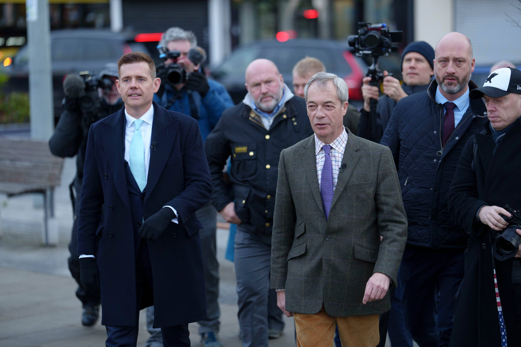 Reform leader Nigel Farage, centre right, walks with prospective candidate Matt Goodwin, left, during a campaign visit to Gorton and Denton in Manchester, England, Friday, Jan. 30, 2026. (AP Photo/Jon Super)