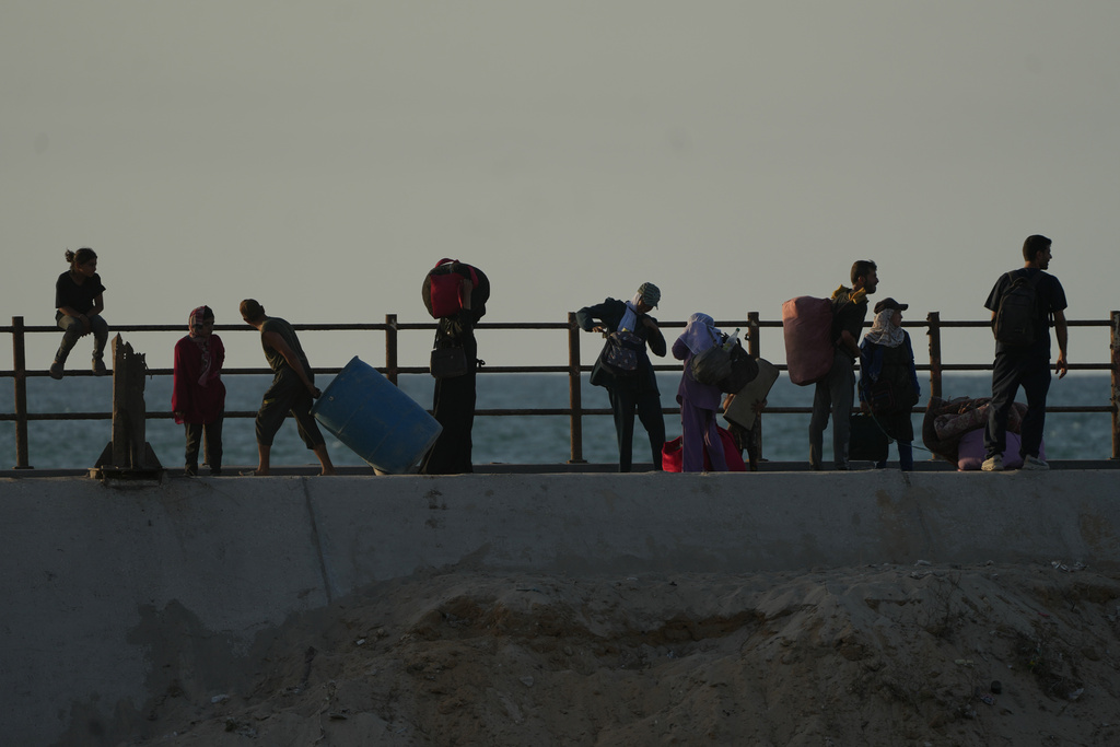 Displaced Palestinians flee northern Gaza carrying their belongings along the coastal road near Wadi Gaza, Thursday, Oct. 2, 2025. (AP Photo/Abdel Kareem Hana)