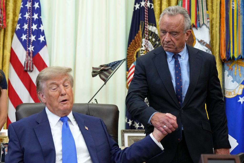 President Donald Trump, left, shakes the hand of Health and Human Services Secretary Robert F. Kennedy Jr. during a meeting to sign an executive order about vaccines, Monday, Aug. 10, 2026, in the Oval Office of the White House in Washington. (AP Photo/Jacquelyn Martin)
