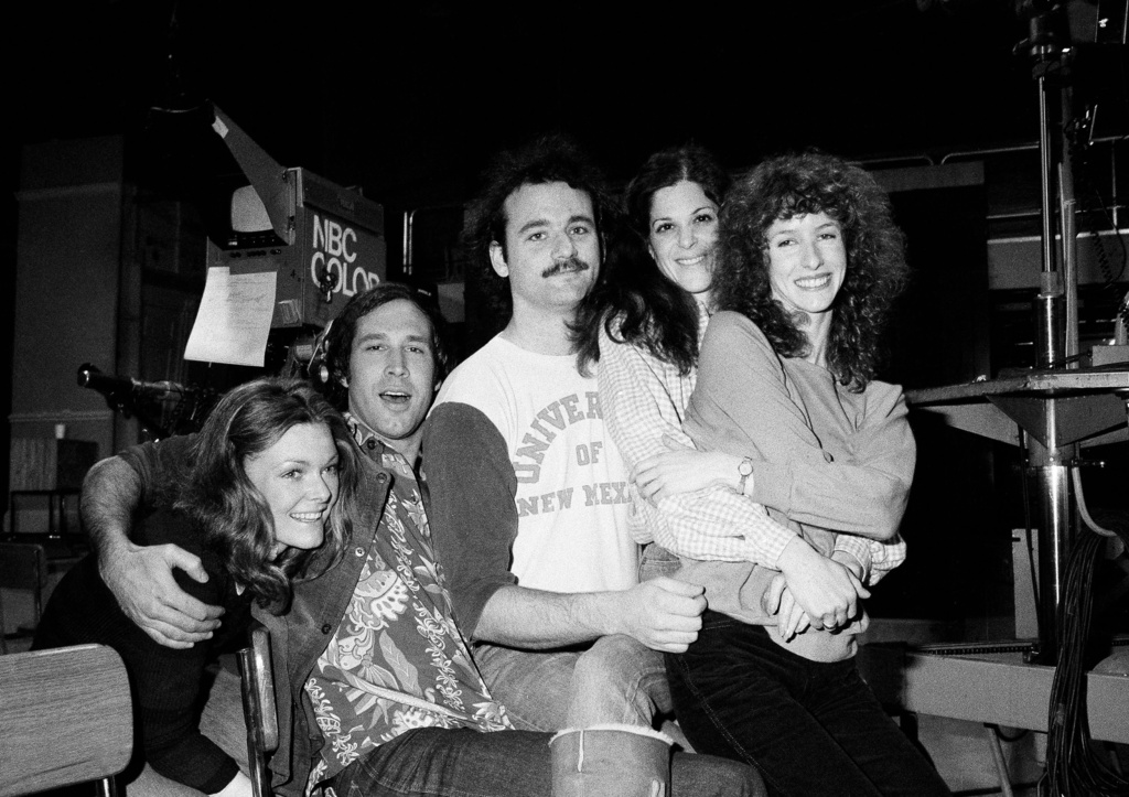 FILE - Comedian Chevy Chase, second from left, joins cast of NBC-TV's "Saturday Night Live," Feb. 16, 1978 in New York, where he first got his start with the "Not Ready For Prime Time Players." Others are, from left, Jane Curtin, Bill Murray, Gilda Radner, and Laraine Newman. Chase is doing a guest shot on the program. (AP Photo/Marty Lederhandler, File)