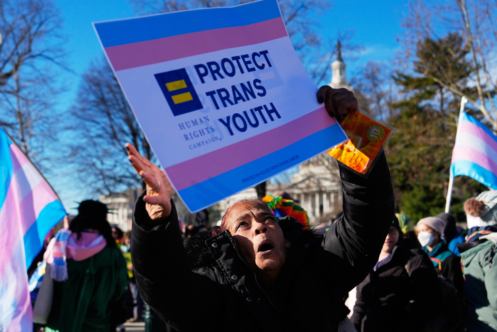 Protesters gather outside the Supreme Court as it hears arguments over state laws barring transgender girls and women from playing on school athletic teams, Tuesday, Jan. 13, 2026, in Washington. (AP Photo/Julia Demaree Nikhinson)