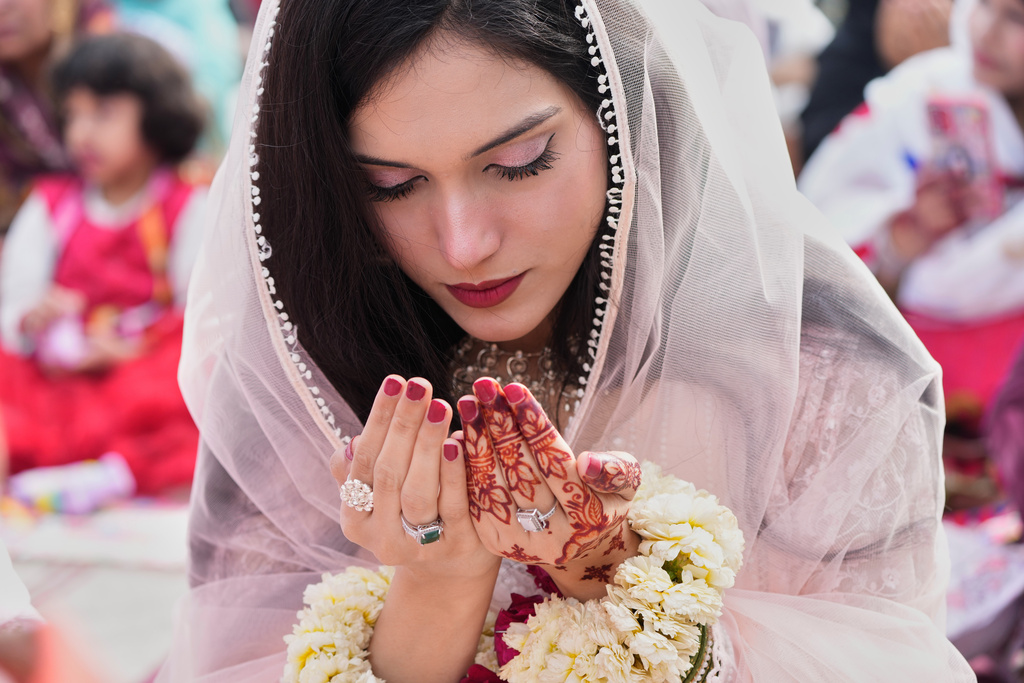 A Muslim woman attends Eid al-Fitr prayer, marking the end of the Muslim's holy fasting month of Ramadan, at the historical Badshahi Mosque in Lahore, Pakistan, Saturday, March 21, 2026. (AP Photo/K.M. Chaudary)