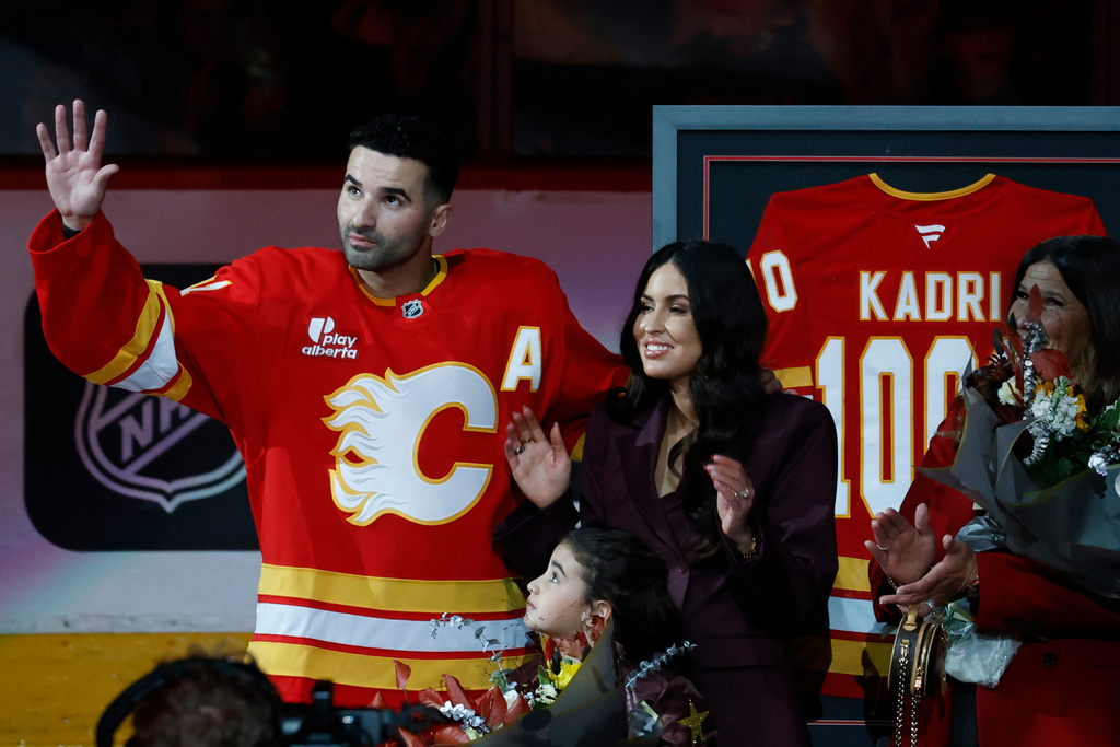 Calgary Flames' Nazem Kadri is honoured with a silver stick for his 1000th NHL game alongside his wife Ashley Cave and daughter Naylah prior to game action against the Columbus Blue Jackets in Calgary on Wednesday, Nov. 5, 2025. (Larry MacDougal/The Canadian Press via AP)