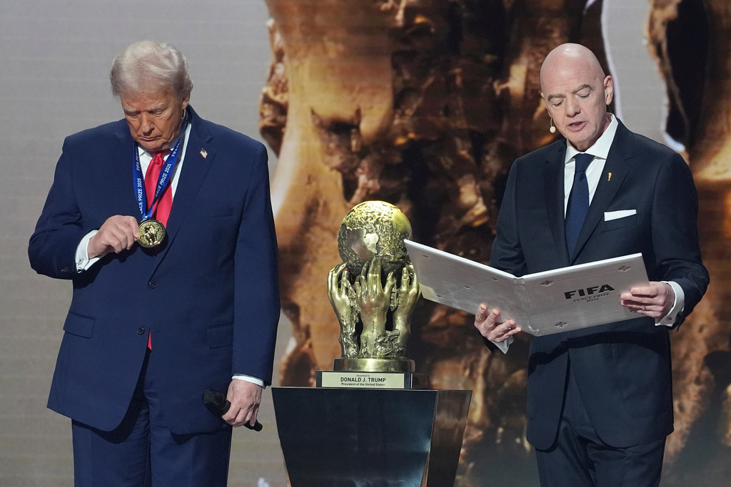 President Donald Trump is presented with the inaugural FIFA Peace Prize by FIFA President Gianni Infantino during the 2026 FIFA World Cup draw at the Kennedy Center, Friday, Dec. 5, 2025, in Washington. (AP Photo/Evan Vucci)