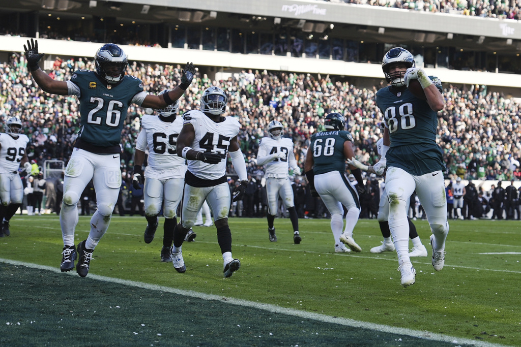 Philadelphia Eagles tight end Dallas Goedert (88) runs for a touchdown as Eagles running back Saquon Barkley (26) reacts during the second half of an NFL football game against the Las Vegas Raiders on Sunday, Dec. 14, 2025, in Philadelphia. (AP Photo/Matt Slocum)