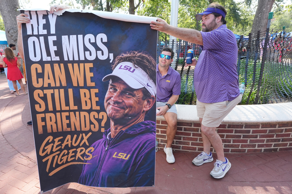 LSU fans hold a poster supporting current LSU football coach Lane Kiffin, who was the former head coach at Mississippi, prior to their NCAA college football game against Mississippi in Oxford, Miss., Saturday, Sept. 19, 2026. (AP Photo/Rogelio V. Solis)