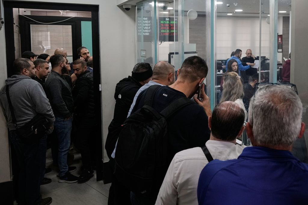 People wait in line to buy gold and silver ounces at a gold and silver trader in the Beirut suburb of Bourj Hammoud, Lebanon, Monday, Feb. 2, 2026. (AP Photo/Bilal Hussein)