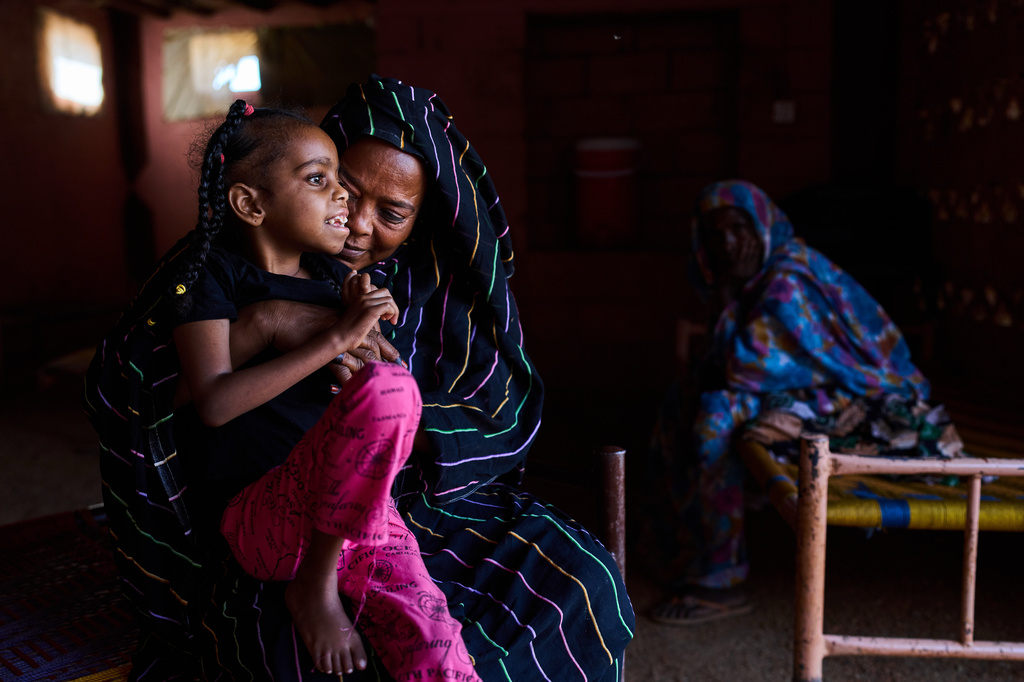 Rashiqa Alqadi holds her grandchild, Anfal Aljozoor, 11, who has a disability and suffers from epilepsy, at the family home in Qoz Nafisa village, Khartoum state, Sudan, Wednesday, April 22, 2026. (AP Photo/Bernat Armangue)