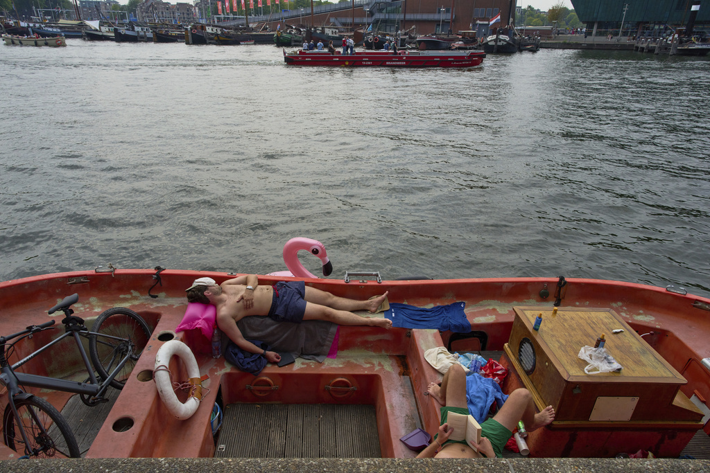 People cool down by the water during hot weather in Amsterdam, Netherlands, Wednesday, Aug. 13, 2025. (AP Photo/Peter Dejong)