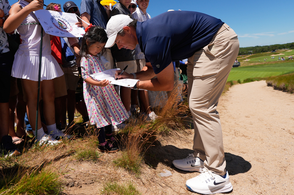 Rory McIlroy, of Northern Ireland, signs autographs during a practice round for the U.S. Open golf tournament at Shinnecock Hills Golf Club in Southampton, N.Y., Monday, June 15, 2026.(AP Photo/David J. Phillip)