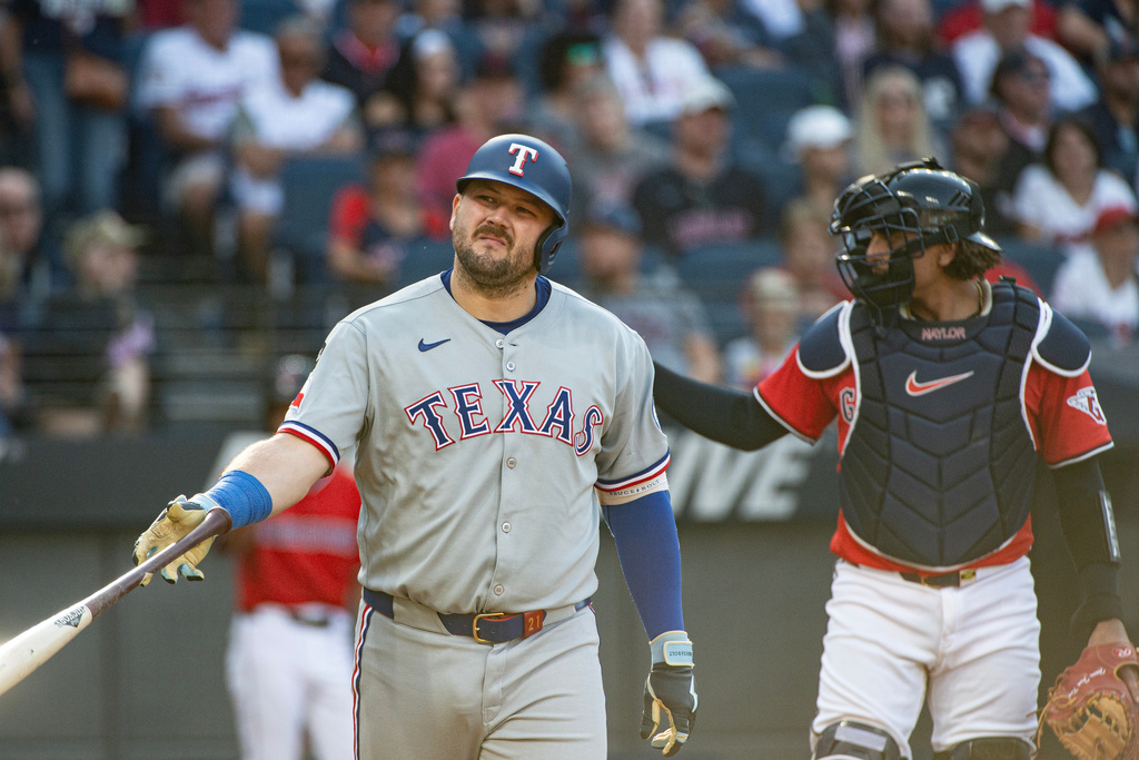 Texas Rangers' Jake Burger, left, reacts after being hit by a pitch from Cleveland Guardians reliever Matt Festa (not shown) during the fifth inning of a baseball game, Sunday, Sept. 28, 2025, in Cleveland. (AP Photo/Phil Long)
