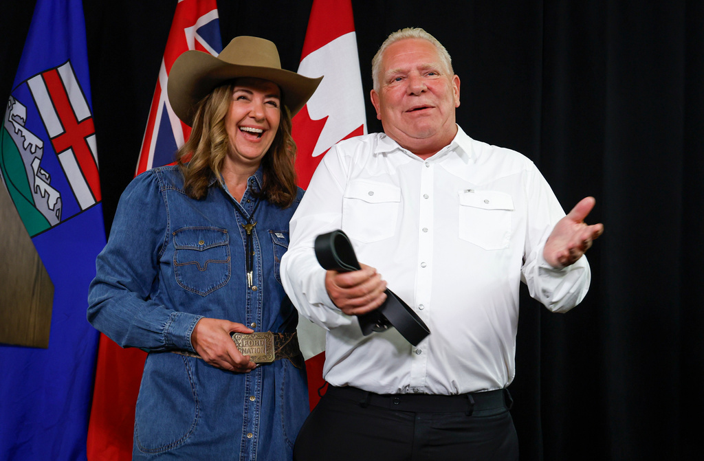 Alberta Premier Danielle Smith, left, and Ontario Premier Doug Ford swap belt buckles after announcing the Northern Shield pipeline proposal in Calgary, Canada, Monday, July 6, 2026. (Jeff McIntosh/The Canadian Press via AP)