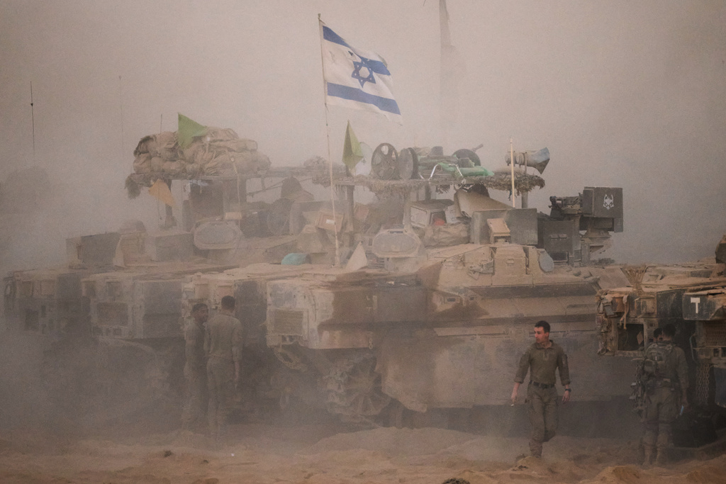 Israeli soldiers stand near their tanks along the Israeli-Gaza border, as seen from southern Israel, Friday, Oct. 10, 2025, after Israel and Hamas have agreed to a pause in their war and the release of the remaining hostages. (AP Photo/Emilio Morenatti)