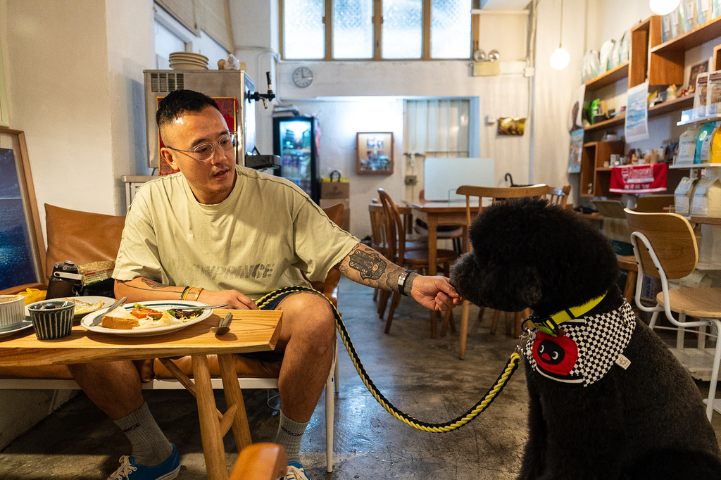 A customer feeds his dog inside the Wan Land Cafe on the first day dogs are legally permitted in restaurants in Hong Kong, Thursday, July 9, 2026. (AP Photo/Chan Long Hei)