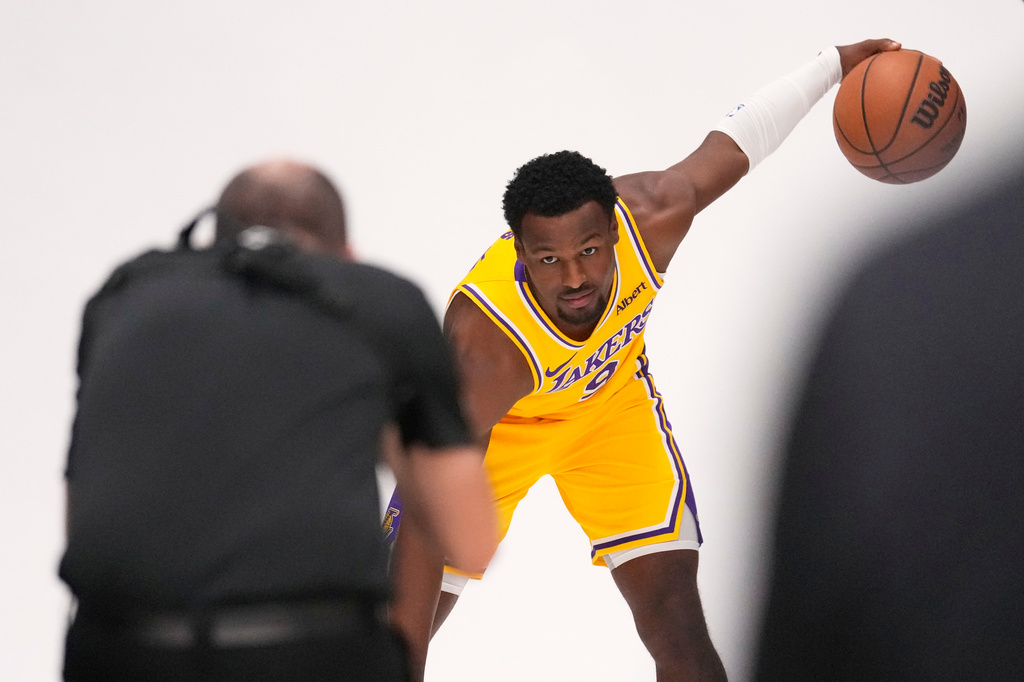 Los Angeles Lakers guard Bronny James poses for pictures with NBA photographer Adam Pantozzi during media day Monday, Sept. 28, 2026, in El Segundo, Calif. (AP Photo/Mark J. Terrill)