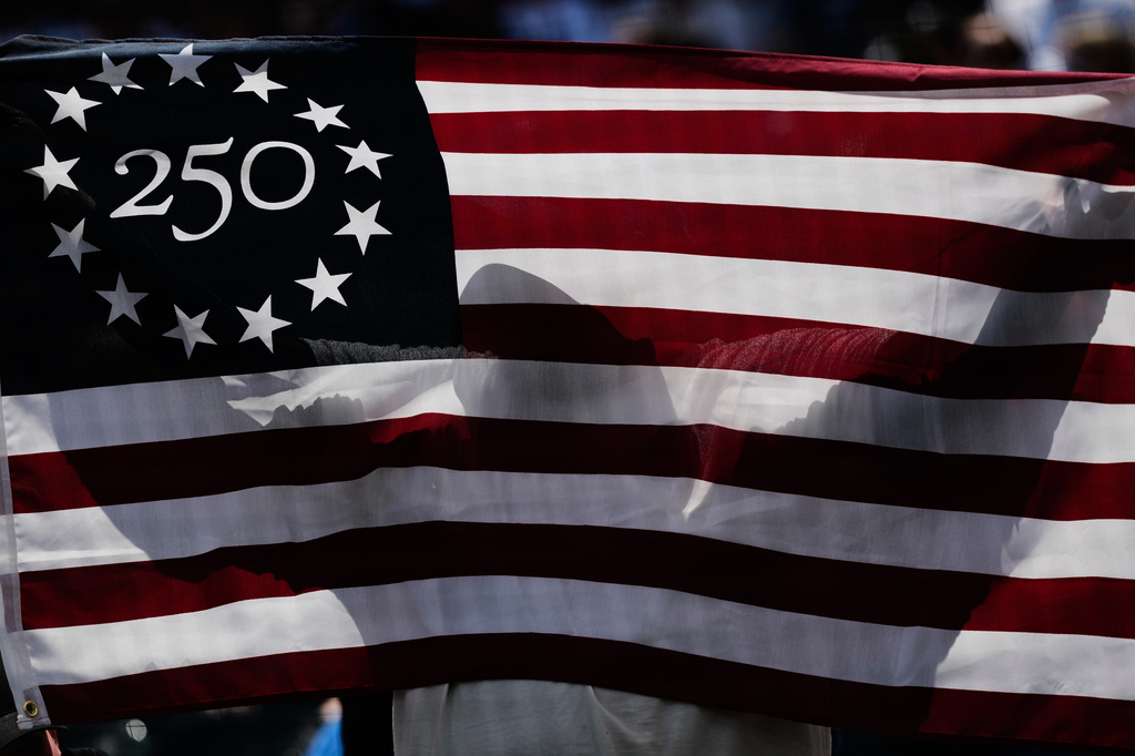 A baseball fan holds a flag for Memorial Day after first inning of a baseball game between the Minnesota Twins and the Chicago White Sox in Chicago, Monday, May 25, 2026. (AP Photo/Nam Y. Huh)