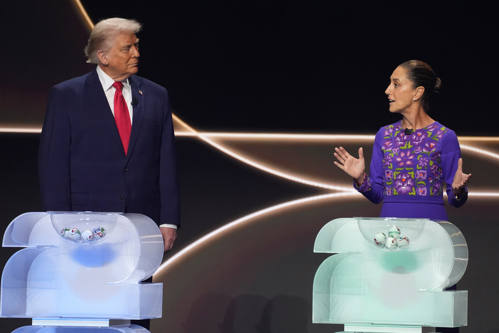 FILE - Mexican President Claudia Sheinbaum, right, speaks as President Donald Trump, left, stands on stage during the draw for the 2026 soccer World Cup at the Kennedy Center in Washington, Dec. 5, 2025. (AP Photo/Evan Vucci, File)