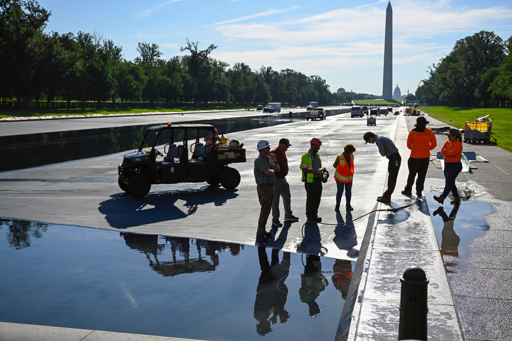Workers refill the Lincoln Memorial Reflecting Pool after several months of repairs on Friday, June 5, 2026, in Washington. (AP Photo/John McDonnell)