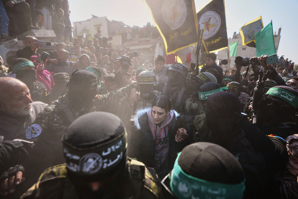 Israeli captive Arbel Yehoud, 29, who has been held hostage by Hamas in Gaza since Oct. 7, 2023, is escorted by Hamas and Islamic Jihad fighters as she is handed over to the Red Cross in Khan Younis, southern Gaza Strip, Thursday Jan. 30, 2025. (AP Photo/Abdel Kareem Hana)