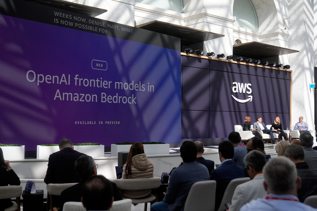 Attendees listen as Denise Dresser, chief revenue officer of OpenAI, second from right on stage, speaks with Julia White, vice president & chief marketing officer, AWS, from stage left, Matt Garman, CEO of AWS, and Anthony Ligouri, vice president and distinguished engineer, AWS, at a What's Next with AWS event Tuesday, April 28, 2026, in San Francisco. (AP Photo/Jeff Chiu)