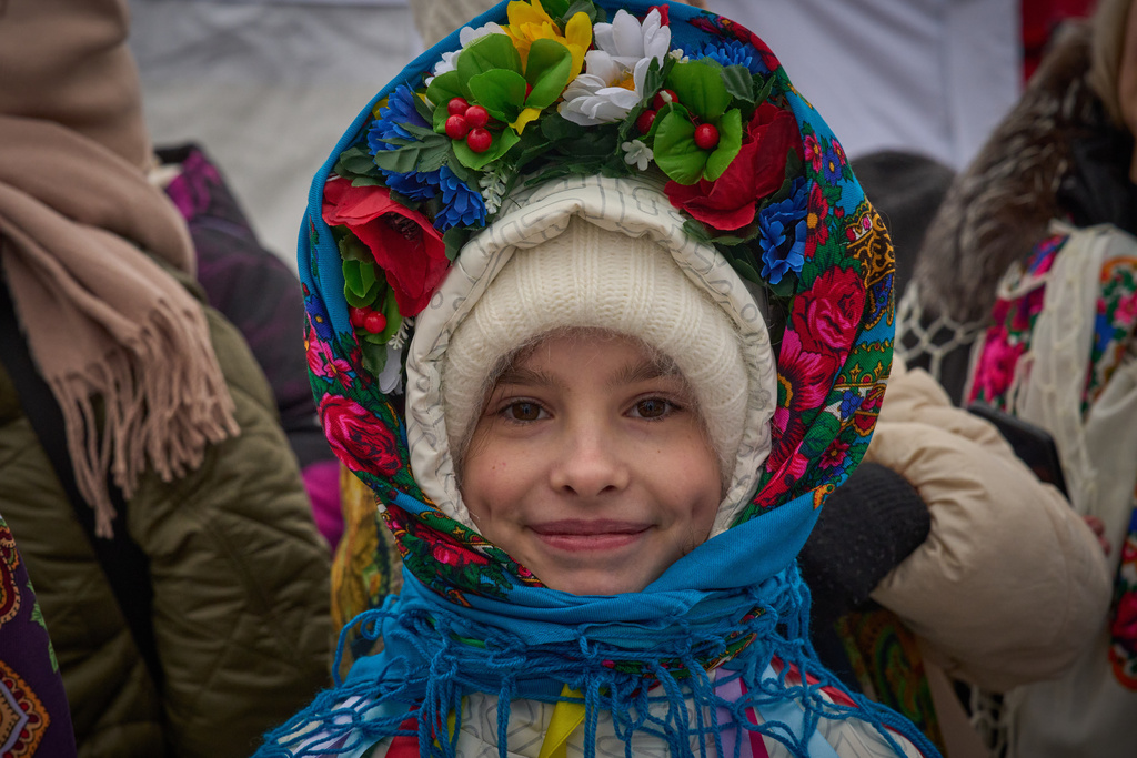 A girl watches people plunging into icy water during celebrations of Epiphany in Kyiv, Ukraine, Tuesday, Jan. 6, 2026. (AP Photo/Efrem Lukatsky)