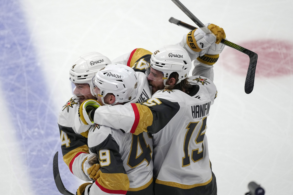 Vegas Golden Knights left wing Ivan Barbashev, center, is congratulated by Vegas Golden Knights defensemen Rasmus Andersson, left, and Noah Hanifin during the third period in Game 2 of the Western Conference finals NHL hockey Stanley Cup playoff series against the Colorado Avalanche Friday, May 22, 2026, in Denver. (AP Photo/David Zalubowski)
