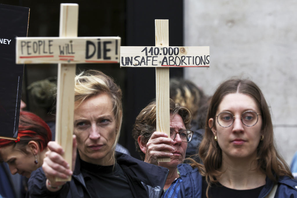 Participants from various women's rights organizations hold signs as they demonstrate regarding the destruction of family planning supplies stockpiled in Belgium, near the U.S. embassy in Brussels, Thursday, Sept. 18, 2025. (AP Photo/Omar Havana)