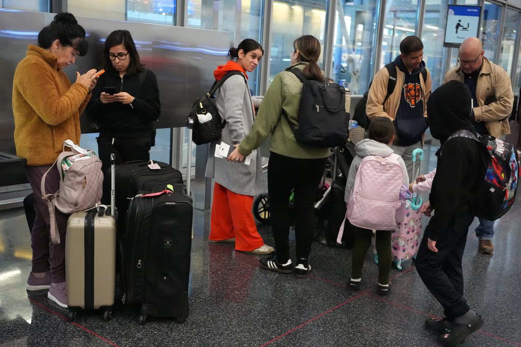 Travelers check their flight status at O'Hare International Airport in Chicago, Friday, Nov. 7, 2025. (AP Photo/Nam Y. Huh)