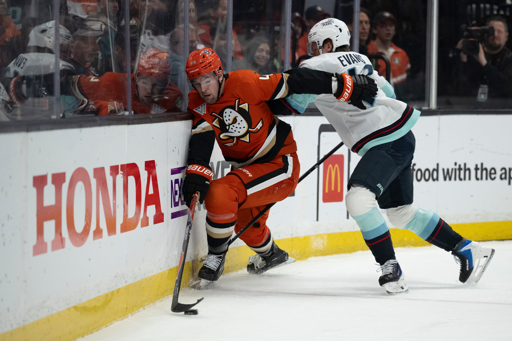 Anaheim Ducks left wing Ross Johnston (44) controls the puck away from Seattle Kraken defenseman Ryker Evans (41) during the first period of an NHL hockey game, Tuesday, Feb. 3, 2026, in Anaheim, Calif. (AP Photo/Kyusung Gong)