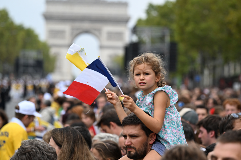 People wait for Pope Leo XIV on the Champs Elysees avenue before a mass at the Place de la Concorde in Paris, Saturday, Sept. 26, 2026. (AP Photo/Emma Da Silva)