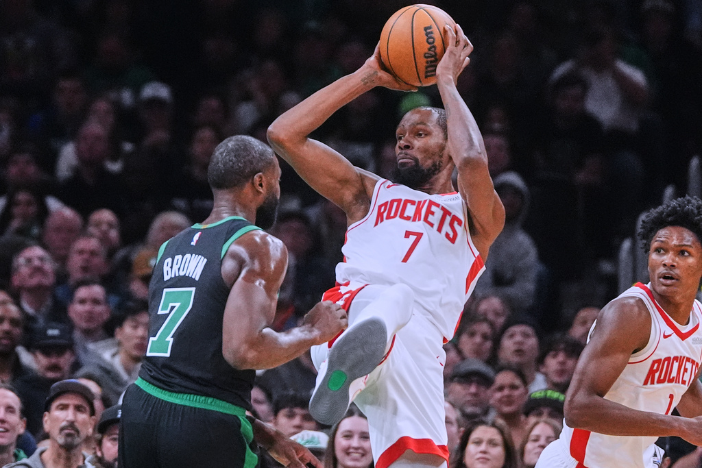 Houston Rockets forward Kevin Durant, right, looks to pass while pressured by Boston Celtics forward Jaylen Brown during the second half of an NBA basketball game Saturday, Nov. 1, 2025, in Boston. (AP Photo/Charles Krupa)