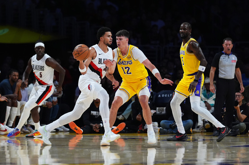 Portland Trail Blazers forward Toumani Camara, center left, is defended by Los Angeles Lakers forward Jake LaRavia (12) during the first half of an NBA basketball game Monday, Oct. 27, 2025, in Los Angeles. (AP Photo/Ethan Swope) Portland Trail Blazers forward Toumani Camara, center left, is defended by Los Angeles Lakers forward Jake LaRavia (12) during the first half of an NBA basketball game Monday, Oct. 27, 2025, in Los Angeles. (AP Photo/Ethan Swope)