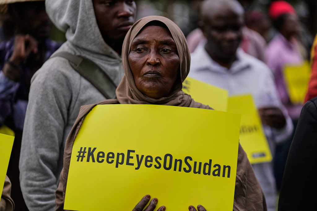 A woman holds a placard during a tree planting event commemorating the war in Sudan as it enters its fourth year, in Nairobi, Kenya, Wednesday, April 15, 2026. (AP Photo/Brian Inganga)