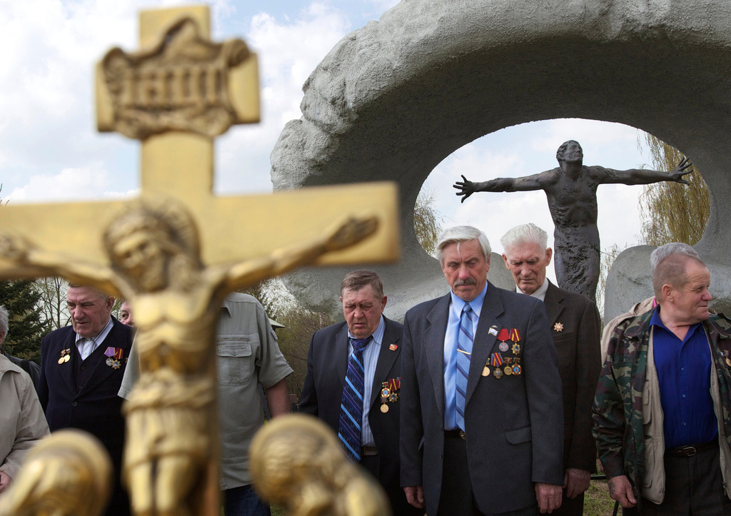 FILE - Firefighters visit Mitinskoye Cemetery in Moscow, Russia, on Thursday, April 26, 2012, to honor those who died responding to the explosion and fire at the Chernobyl nuclear power plant on April 26, 1986. (AP Photo/Ivan Sekretarev, File)