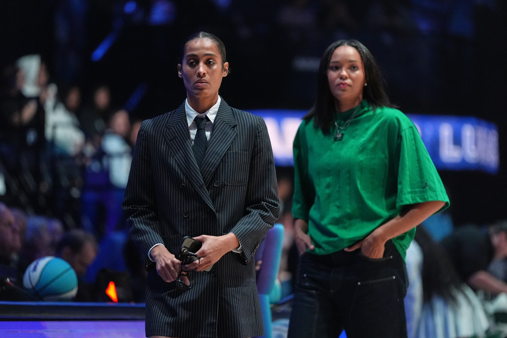Lunar Owls guard Skylar Diggins, left, and forward Napheesa Collier wear street clothes as they sit out the game with injuries, at the start of their Unrivaled 3-on-3 basketball game against Rose BC, Monday, Jan. 5, 2026, in Medley, Fla. (AP Photo/Rebecca Blackwell)