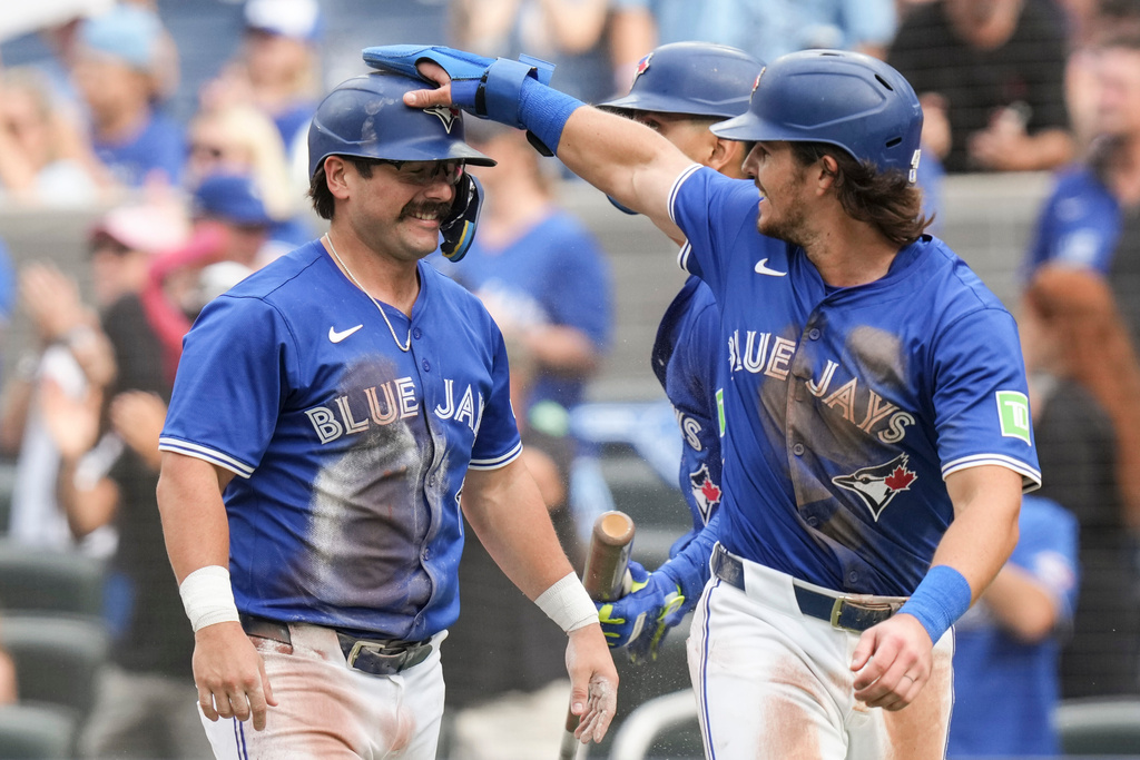 Toronto Blue Jays' Addison Barger (47) and Davis Schneider (36) celebrate after Jays' Ernie Clement hit a two-run double off Tampa Bay Rays pitcher Joe Boyle (36) during the second inning of a baseball game in Toronto, Saturday, Sept. 27, 2025. (Chris Young/The Canadian Press via AP)