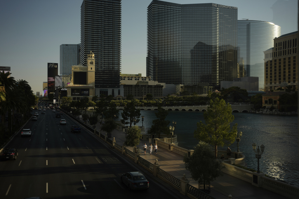 People walk along the Las Vegas Strip, Friday, Aug. 8, 2025, in Las Vegas. (AP Photo/John Locher)