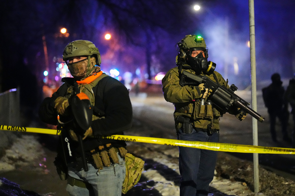 Law enforcement officers at the scene of a reported shooting Wednesday, Jan. 14, 2026, in Minneapolis. (AP Photo/Adam Gray)