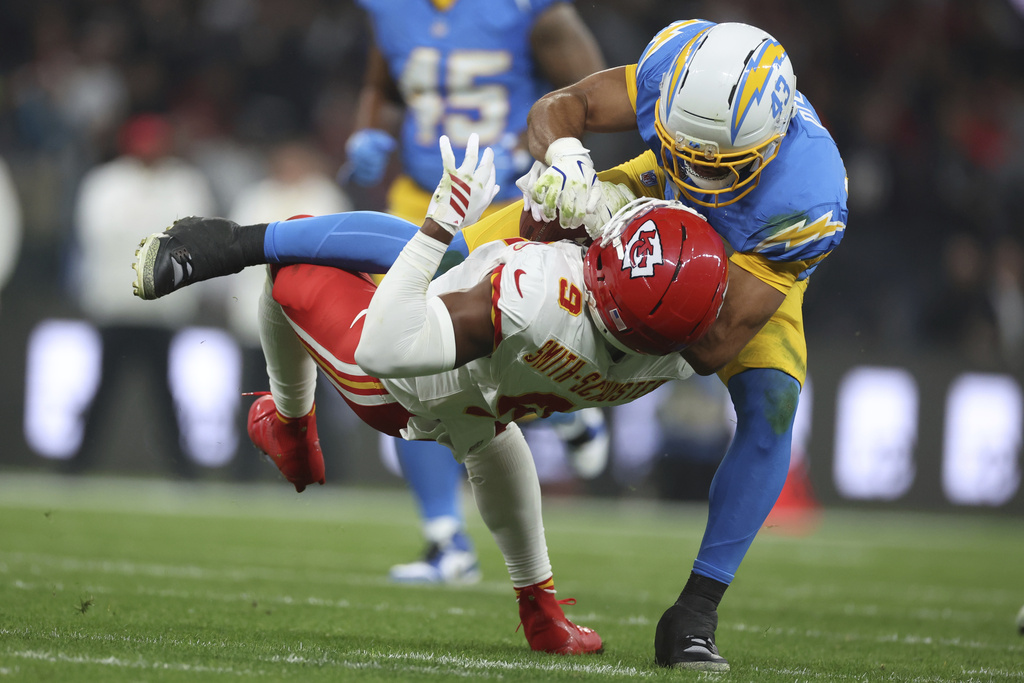 Kansas City Chiefs wide receiver JuJu Smith-Schuster is tackled by Los Angeles Chargers linebacker Troy Dye during the first half of an NFL football game, Friday, Sept. 5, 2025, in Sao Paulo. (AP Photo/Jeff Lewis)
