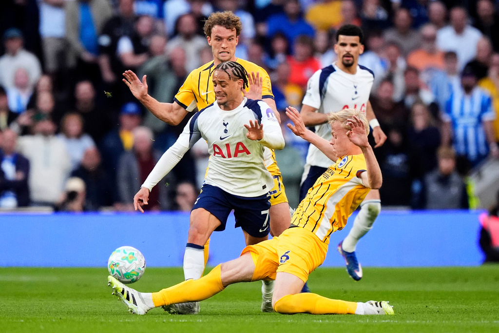 Tottenham Hotspur's Xavi Simons, left, and Brighton and Hove Albion's Jan Paul van Hecke battle for the ball during their English Premier League soccer match in London, Saturday, April 18, 2026. (Jordan Pettitt/PA via AP)