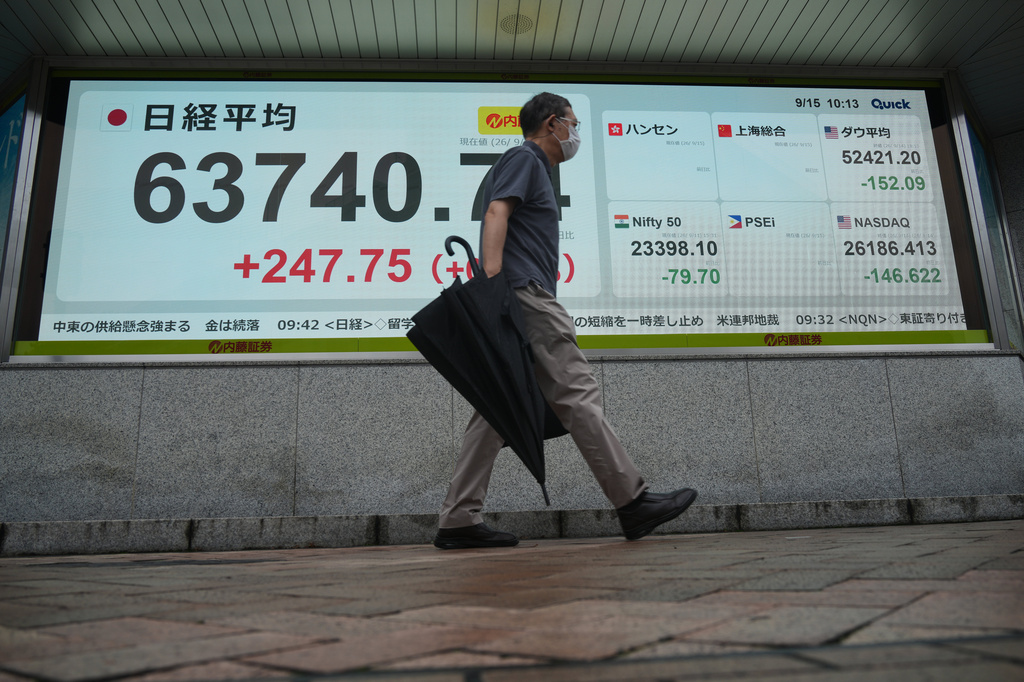 A person walks in front of an electronic stock board showing Japan's Nikkei index at a securities firm Tuesday, Sept. 15, 2026, in Tokyo. (AP Photo/Eugene Hoshiko)