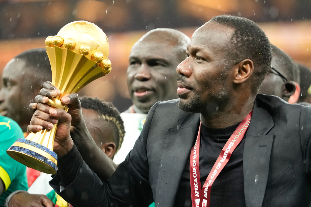 Senegal's head coach Pape Thiaw holds the trophy after winning the Africa Cup of Nations final soccer match agaisnt Morocco, in Rabat, Morocco, Sunday, Jan. 18, 2026. (AP Photo/Mosa'ab Elshamy)