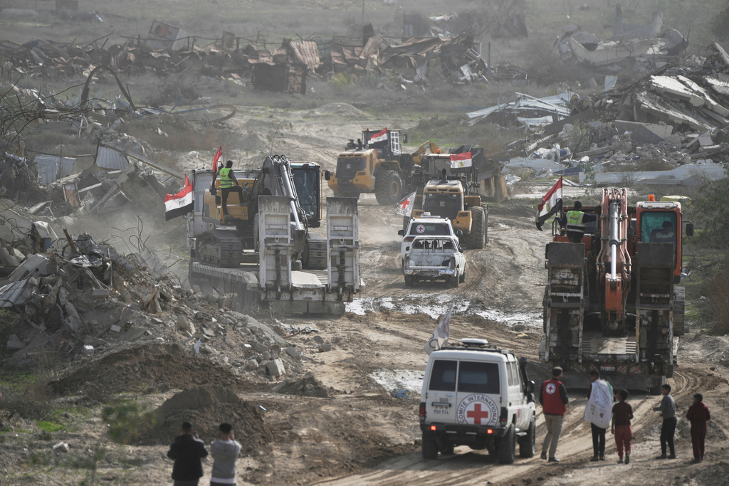 Hamas militants and Egyptian workers accompanied by members of the International Committee of the Red Cross (ICRC) head to Zeitoun neighborhood of Gaza City to search for the remains of deceased hostages, Monday, Dec. 8, 2025. (AP Photo/Jehad Alshrafi)