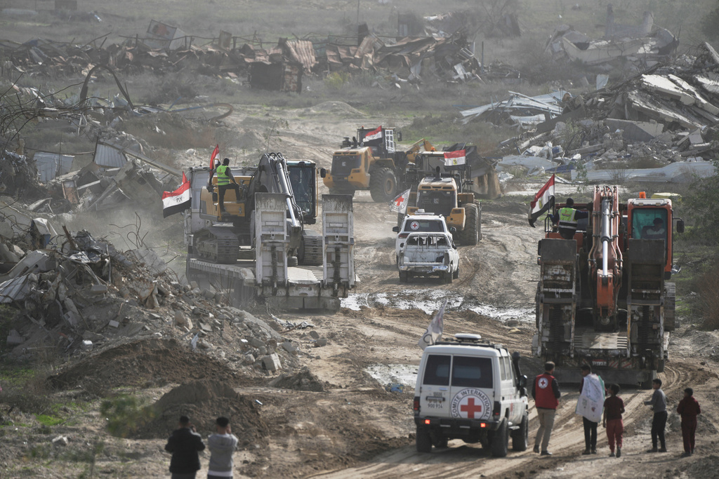 Hamas militants and Egyptian workers accompanied by members of the International Committee of the Red Cross (ICRC) head to Zeitoun neighborhood of Gaza City to search for the remains of the final hostage, Monday, Dec. 8, 2025. (AP Photo/Jehad Alshrafi)