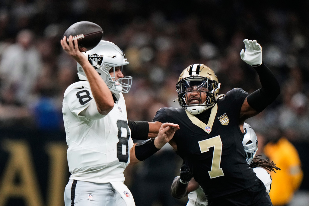 Las Vegas Raiders quarterback Kirk Cousins (8) throws a pass under pressure from New Orleans Saints safety Jonas Sanker (7) during the first half of an NFL football game in New Orleans, Sunday, Sept. 27, 2026. (AP Photo/Gerald Herbert)