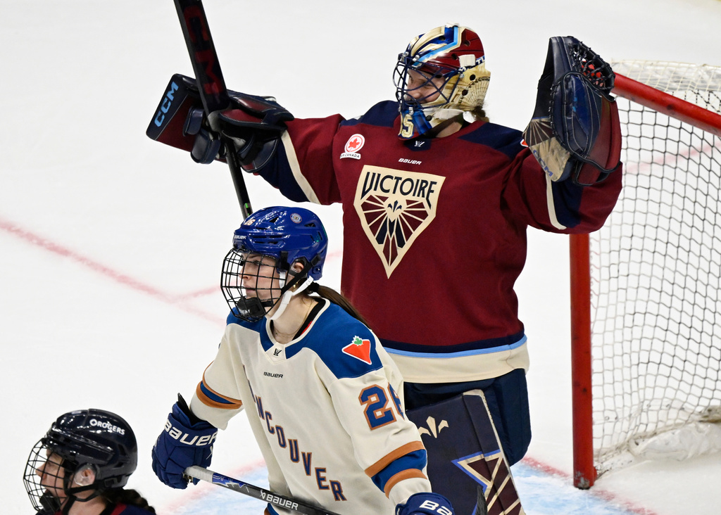 Montreal Victoire goalie Ann-Renee Desbiens, top, celebrates after her shutout as Vancouver Goldeneyes' Brooke McQuigge (26) skates away after PWHL hockey game action in Quebec City, Sunday, Jan. 11, 2026. (Jacques Boissinot/The Canadian Press via AP)