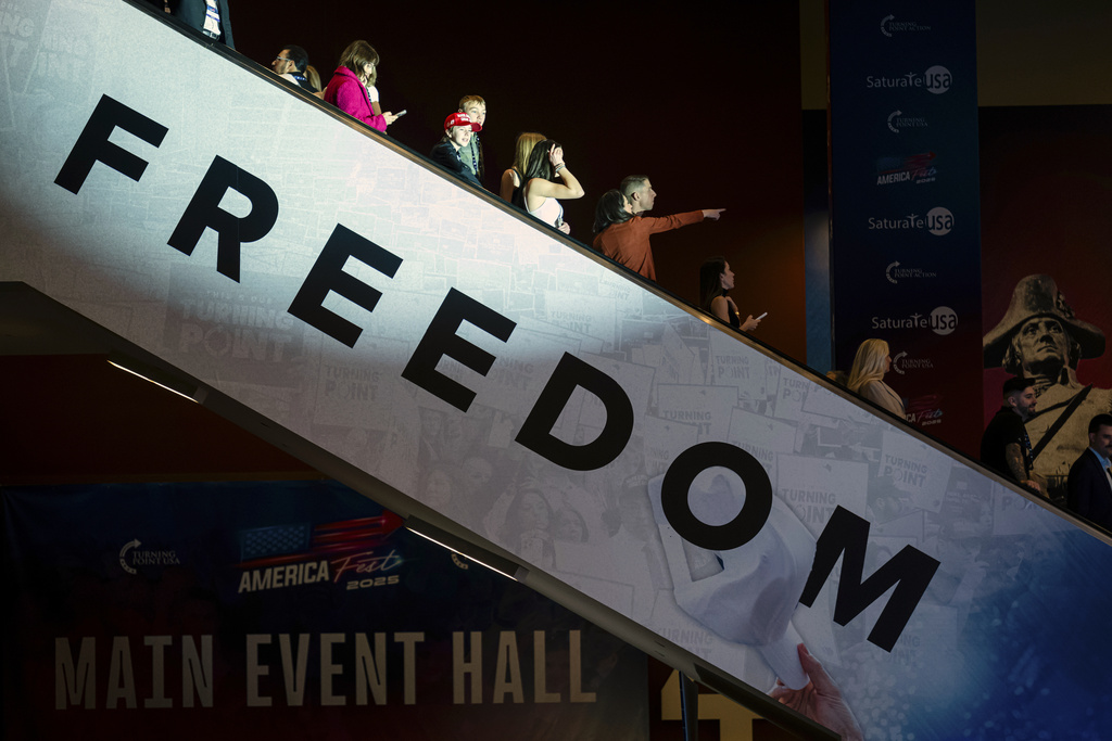 Attendees ride an escalator into the main hall during Turning Point USA's AmericaFest 2025, Thursday, Dec. 18, 2025, in Phoenix. (AP Photo/Jon Cherry)