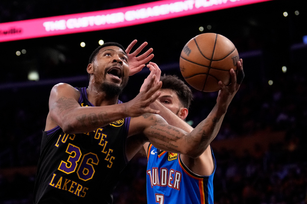 Los Angeles Lakers guard Marcus Smart, left, shoots as Oklahoma City Thunder center Chet Holmgren defends during the first half of Game 4 in a second-round NBA basketball playoffs series Monday, May 11, 2026, in Los Angeles. (AP Photo/Mark J. Terrill)